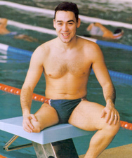David Alonso posando sentado en una de las calles de natación de una piscina