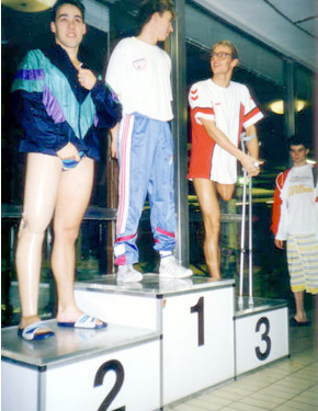 David Alonso, a la izquierda, en el podium, preparado para recibir la medalla de plata en los 100 metros espalda. 