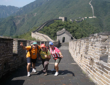 David Alonso con dos compañeros de la expedición posando ante la muralla china