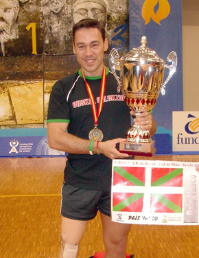 David Alonso posando con el trofeo de campeones y con la bandera de Euskadi