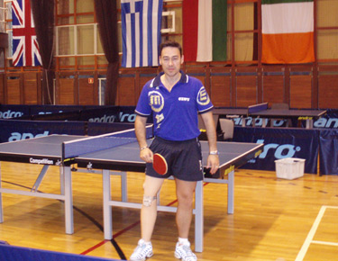 David Alonso posando con pala en mano, en la pista de juego delante de una de las mesas