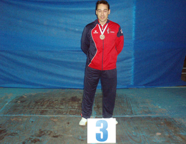 David Alonso posando en el podium con la medalla de bronce colgada al cuello