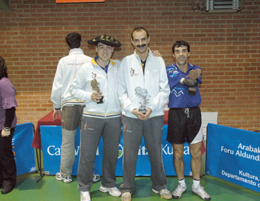 David Alonso, a la izquierda, con la txapela y el trofeo de campeón y con sus compañeros Txema Armentia y el ex-jugador Mauri. 