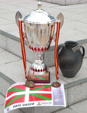 La Copa de Campeón, un diploma y dos medallas expuestas en unas escaleras.