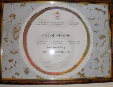 Diploma olímpico enmarcado en la modalidad de los 100 metros mariposa. 